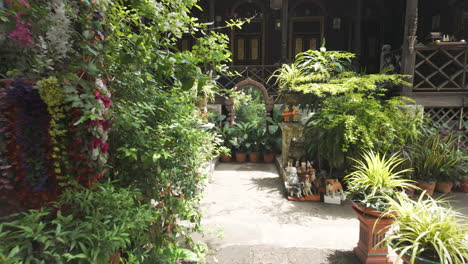 potted plants and statues in the green garden of wat ket karaam temple in chiang mai, thailand. dolly shot