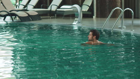 Hombre-Feliz-Nadando-En-Un-Hotel-Moderno-De-Vacaciones.-Hombre-Guapo-Bañándose-En-La-Piscina.