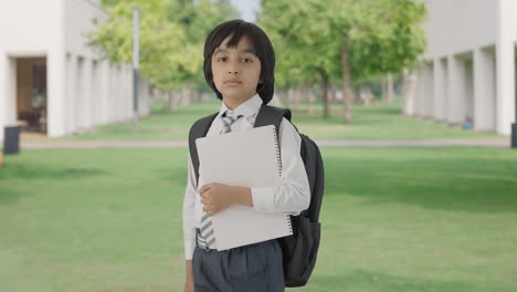retrato de un niño de escuela indio de pie con libros