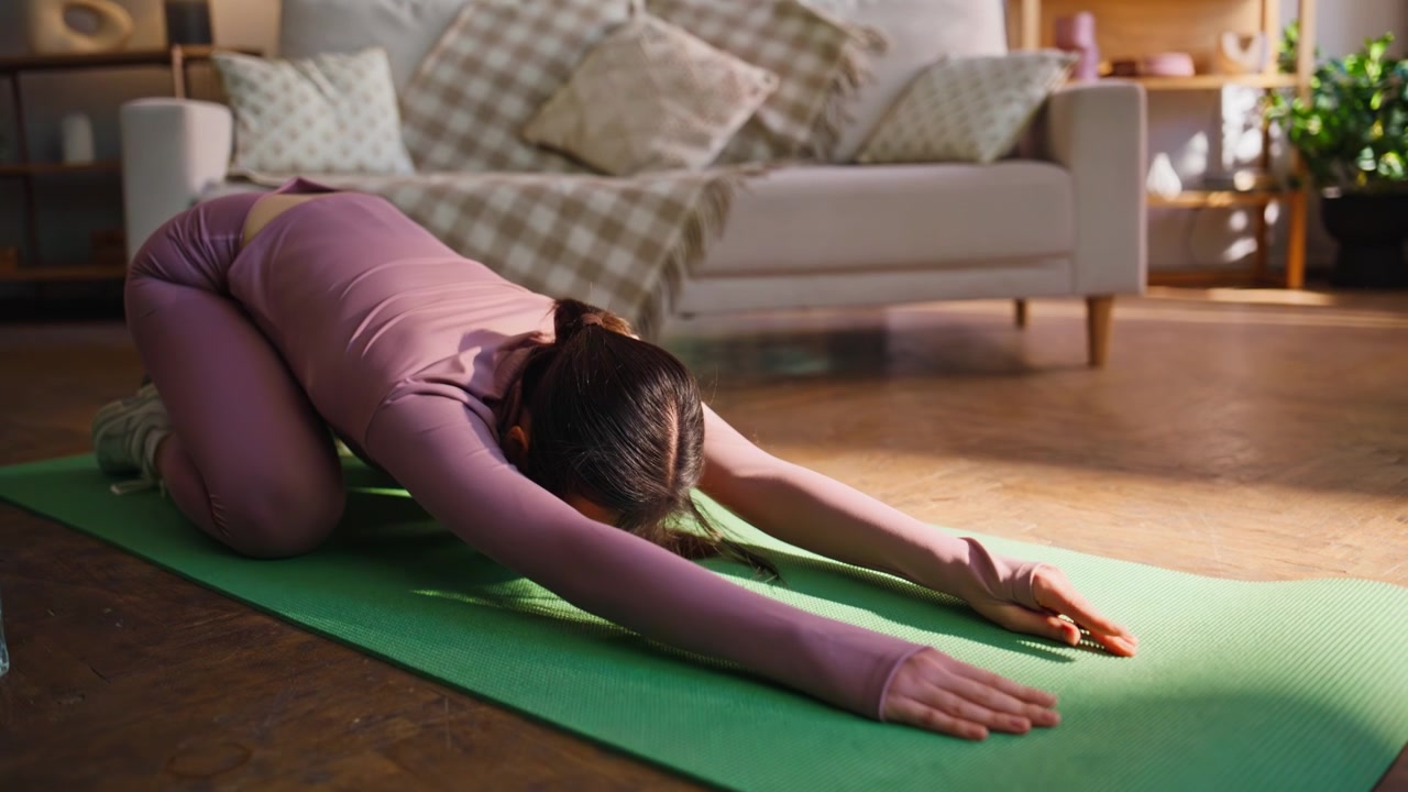Fitness woman doing cat cow yoga stretch home. Asian girl in childs pose workout