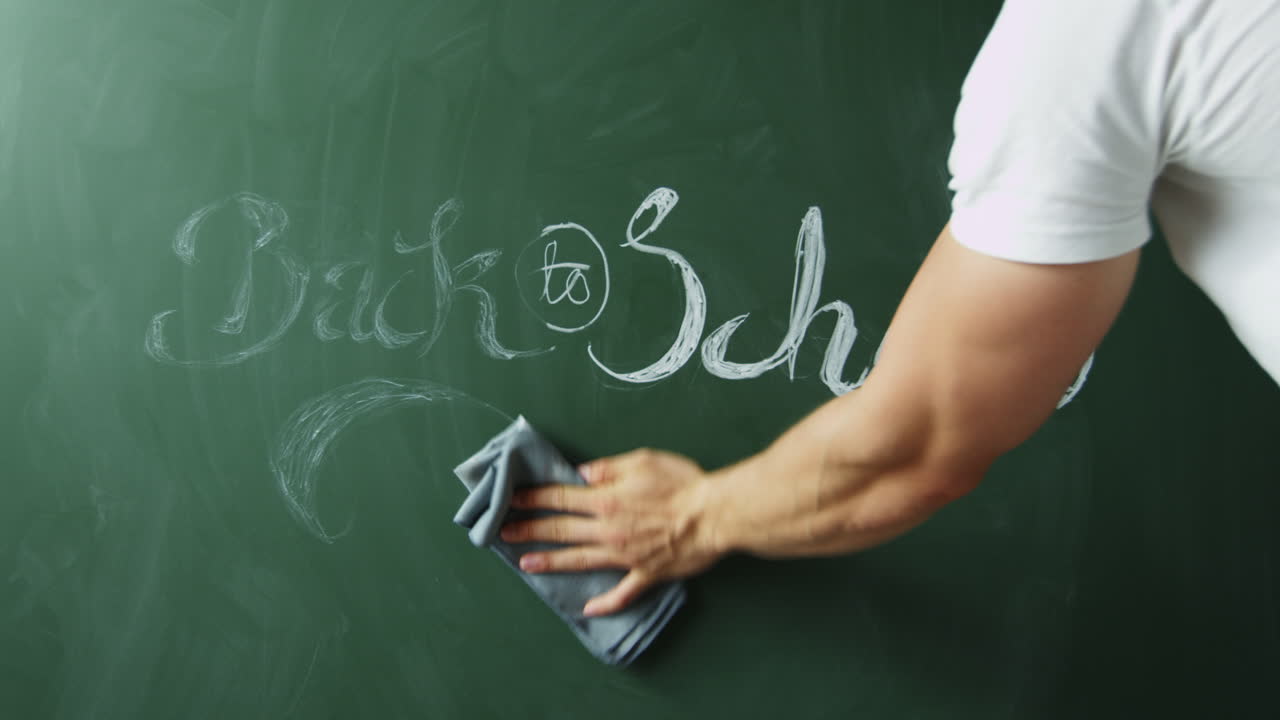 Návrat do školy, muž stírající text z tabule, detailní záběr, natočeno na R3D