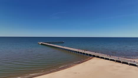 Panoramic-view-a-bridge-standing-on-the-beach-of-Palanga,-which-goes-to-the-Baltic-Sea