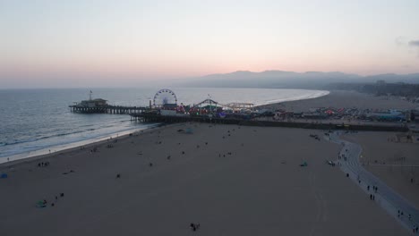super wide aerial panning shot of the santa monica pier and beach at twilight
