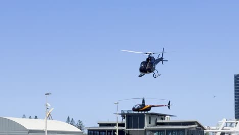 a helicopter hovers above city rooftops with a clear blue sky backdrop.