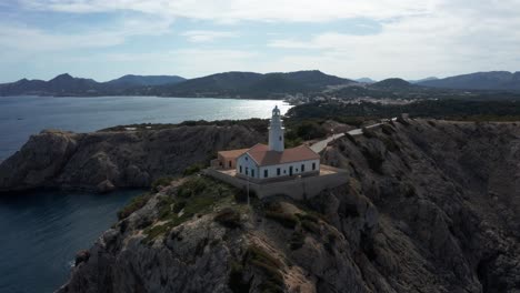 far de capdepera light house in mallorca drone footage during late evening sun with blue ocean in the background