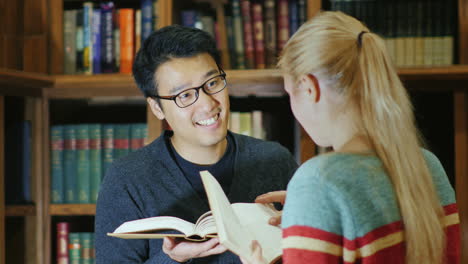 Lächelnder-Koreanischer-Mann,-Der-Mit-Einer-Frau-In-Der-Bibliothek-Spricht-5