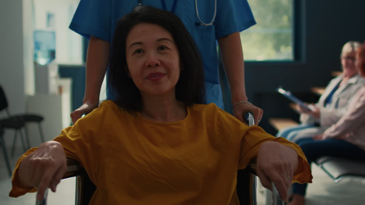 Woman in Wheelchair Assisted by Medical Staff