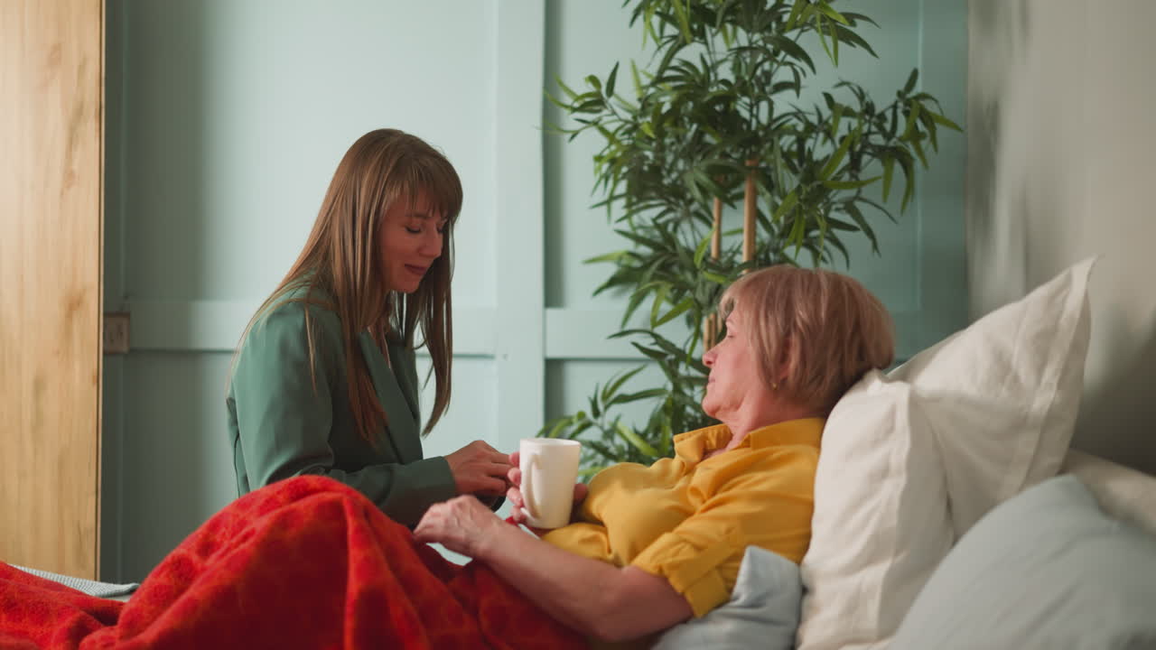 즐거운 며느리가 시어머니에게 약과 차를 줍니다.