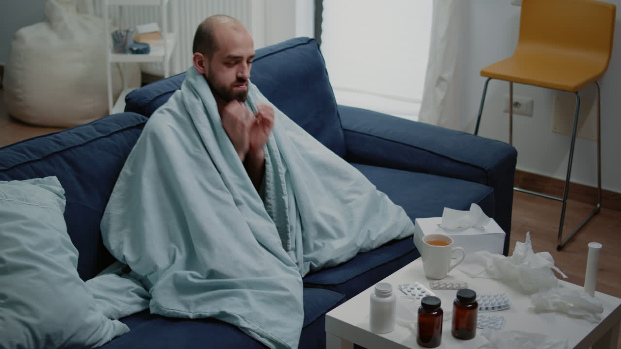 Unwell man with headache rubbing temples and feeling sick