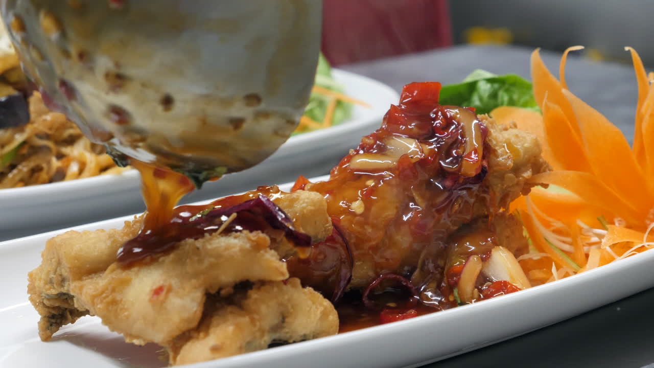 주방 배경이 있는 3가지 맛 칠리 소스를 얹은 타이 다래끼 튀김 농어 생선을 요리하는 주방장을 닫습니다