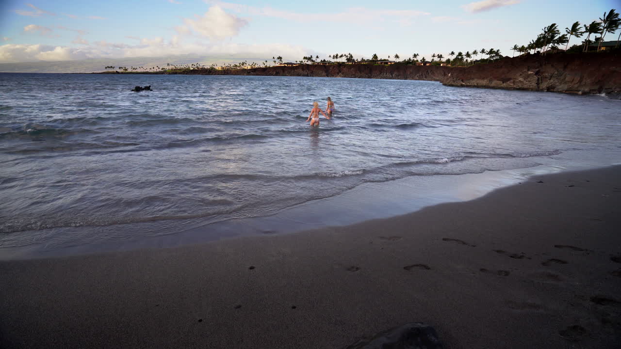 Black Sand Beach Big Island Mauna Lani Hawaii  with people on beach going swimming