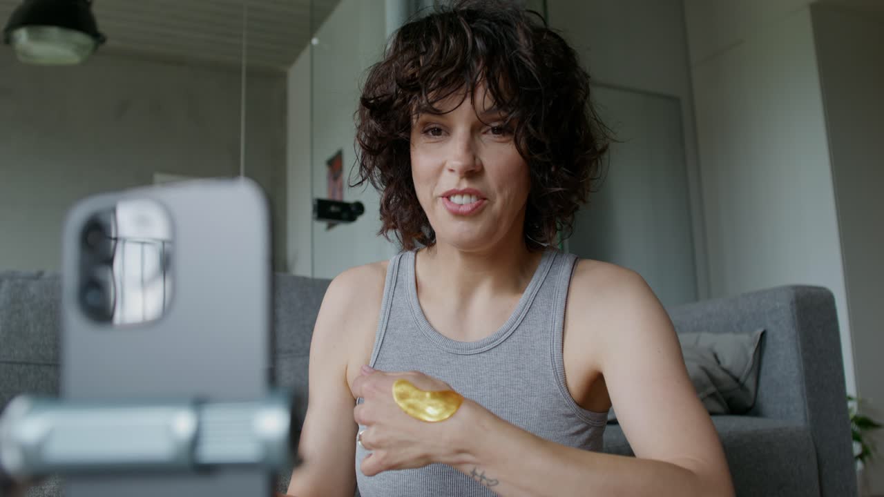 mujer aplicando una máscara de oro durante una llamada de video