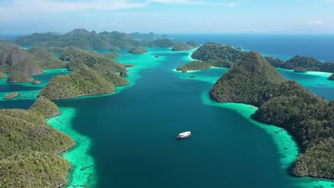 Excelente-Toma-Aérea-De-Un-Barco-Navegando-Entre-Las-Islas-Wayag,-Raja-Ampat,-Indonesia