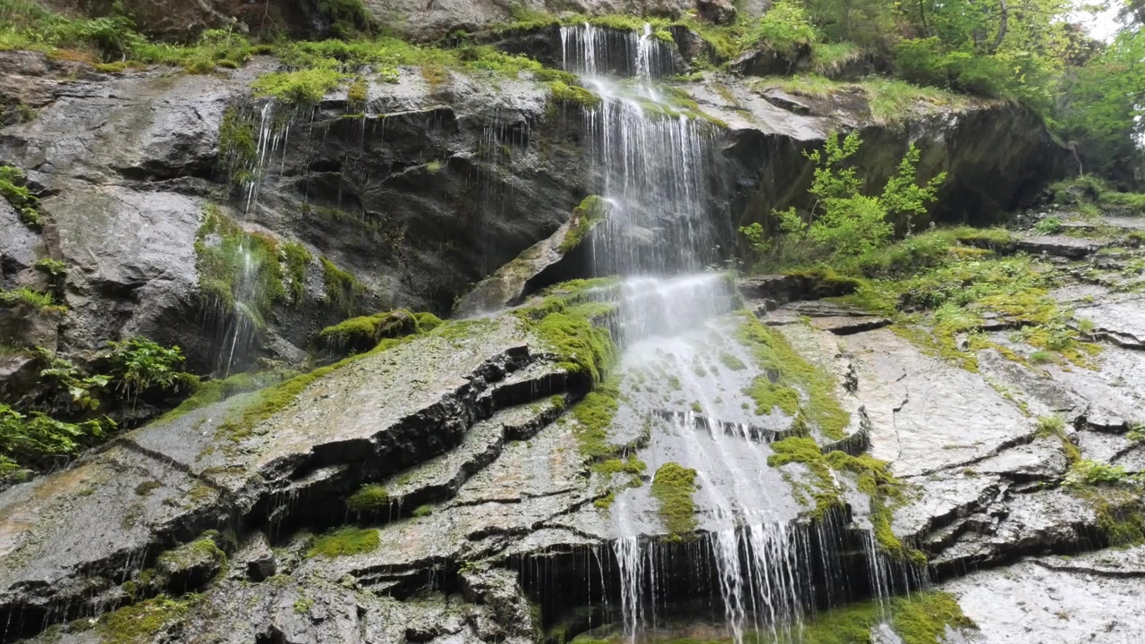 Cascata a più livelli che scende su rocce coperte di muschio a Wimbachklamm, Baviera, Germania.