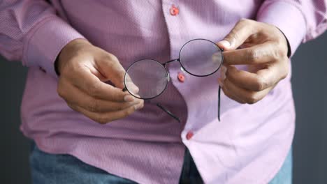 man holding eyeglasses