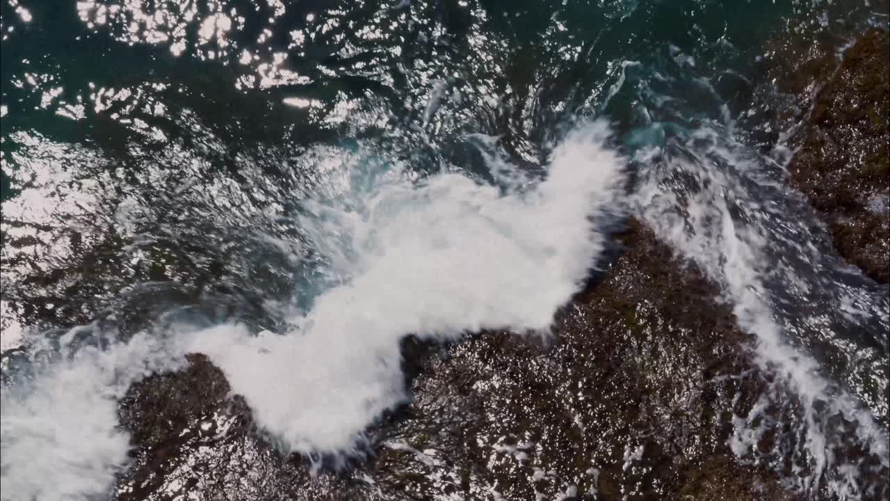 Top-Down View of Ocean Waves Crashing on Rocks