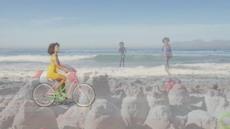 riding bicycle on beach, woman with children playing near sandcastles in animation