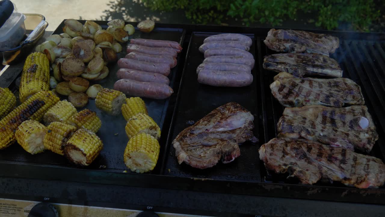 肉が乗ったトレイを調理中のバーベキューグリル。
