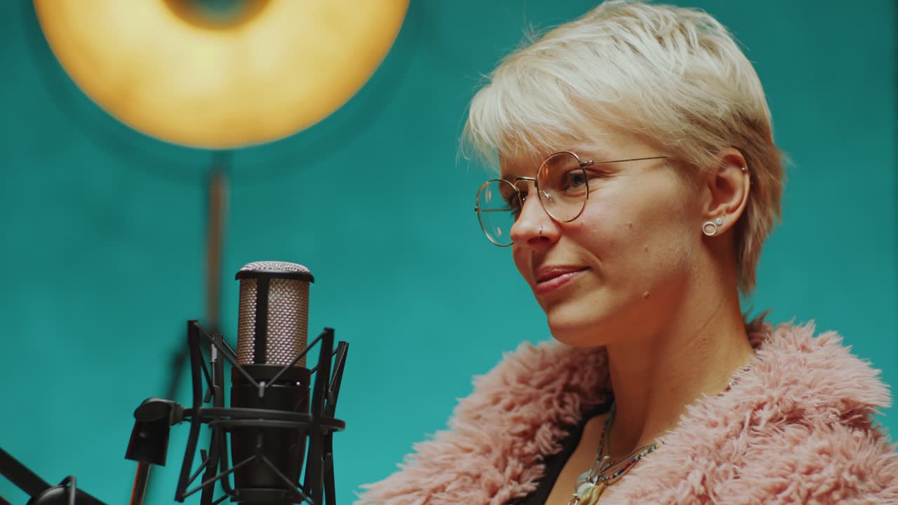 Smuk kvindelig blogger smiler og taler med podcastvært under et interview