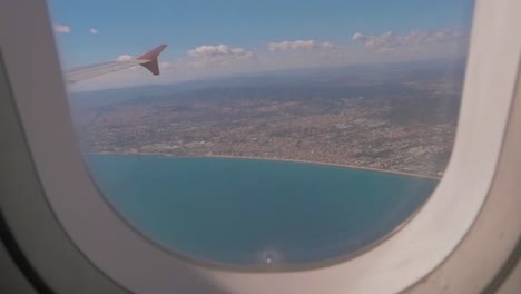 filming from the plane window down onto the beach - city