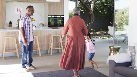 biracial grandparents play with a young biracial girl indoors