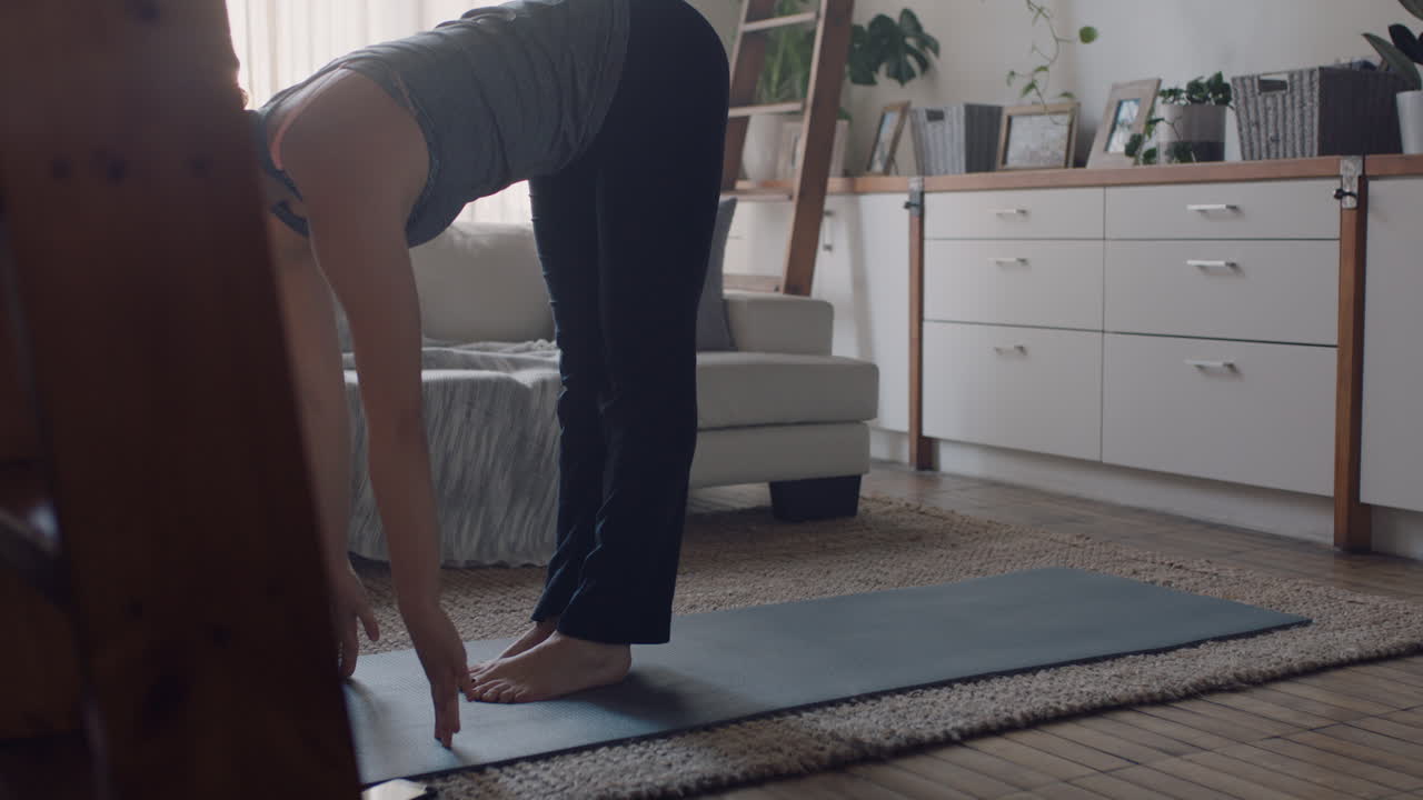 mujer de yoga saludable haciendo ejercicio en casa practicando pose de flexión hacia adelante en la sala de estar disfrutando del entrenamiento físico matutino