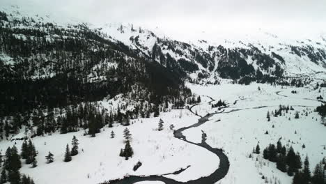 Drohne-Kippt-über-Einen-Kleinen-Fluss-In-Einer-Bergigen-Landschaft-Im-Verschneiten-Alaska