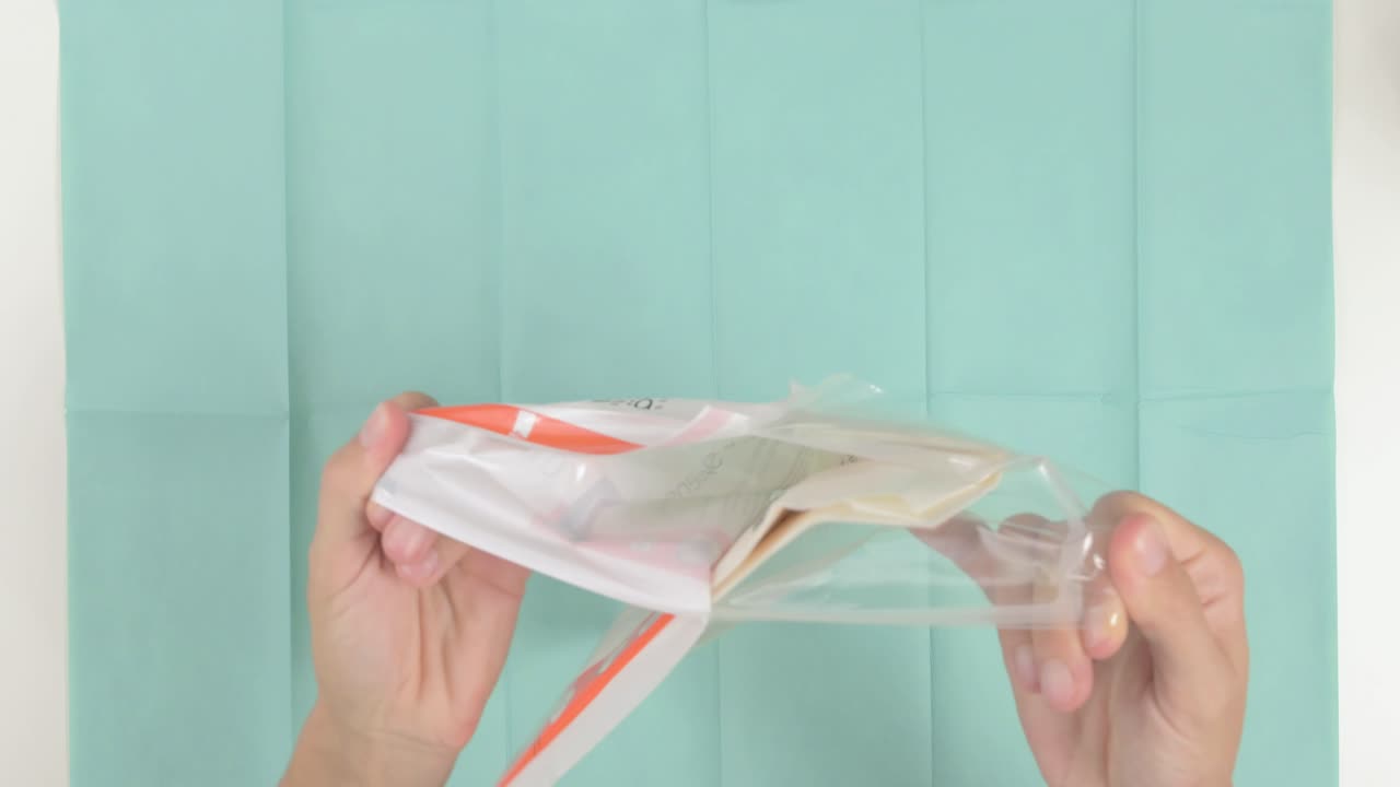 의료 직원이 의료 천에 살균 수술 장갑을 열고 있는 클로즈업