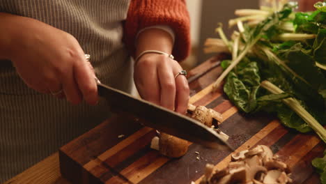 woman cutting mushrooms in kitchen