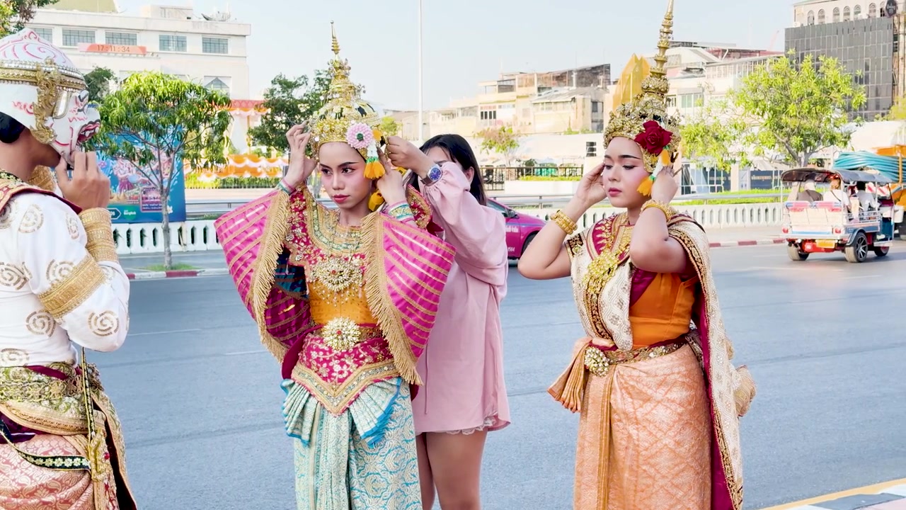 Intérpretes con elaborados tocados dorados y trajes tradicionales tailandeses se preparan para una actuación de danza Khon.