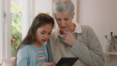 niña linda mostrando a la abuela cómo usar una computadora tablet enseñando a la abuela tecnología moderna niño inteligente ayudando a la abuela con un dispositivo móvil en casa