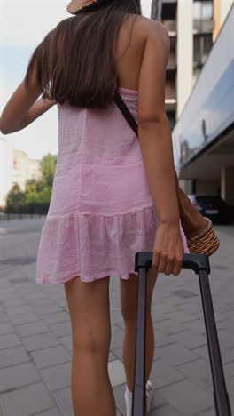 woman walking with luggage in city