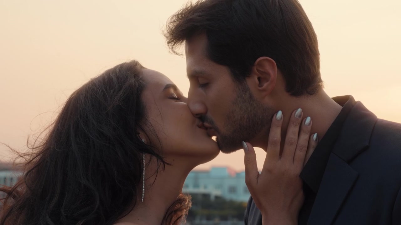 Coppia romantica che si scambia un tenero bacio e un sorriso al tramonto.