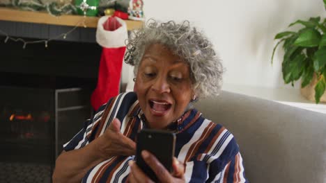 Happy-african-american-senior-woman-gesturing,-having-video-call-at-christmas-time