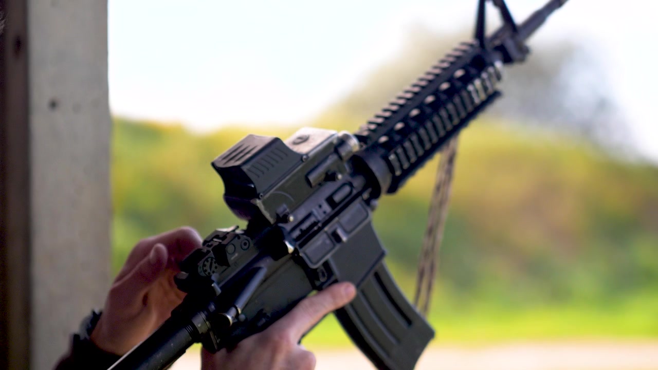 Israeli army soldier inserts magazine and pulls charging handle during training