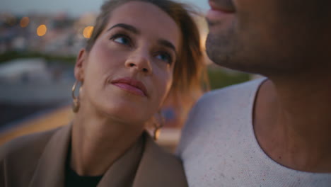 en primer plano, una tierna pareja se besan los labios y se abrazan en las luces de la noche.