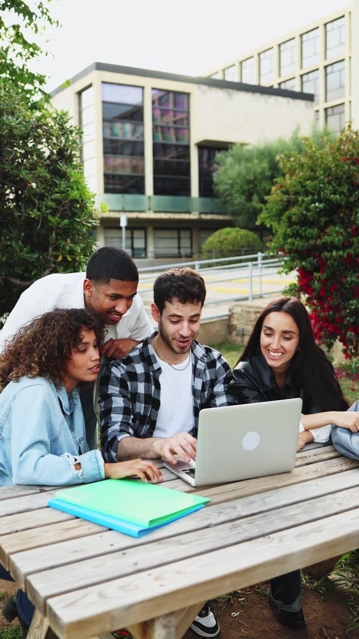 Un gruppo diverso di studenti che collabora al laptop nel campus universitario.
