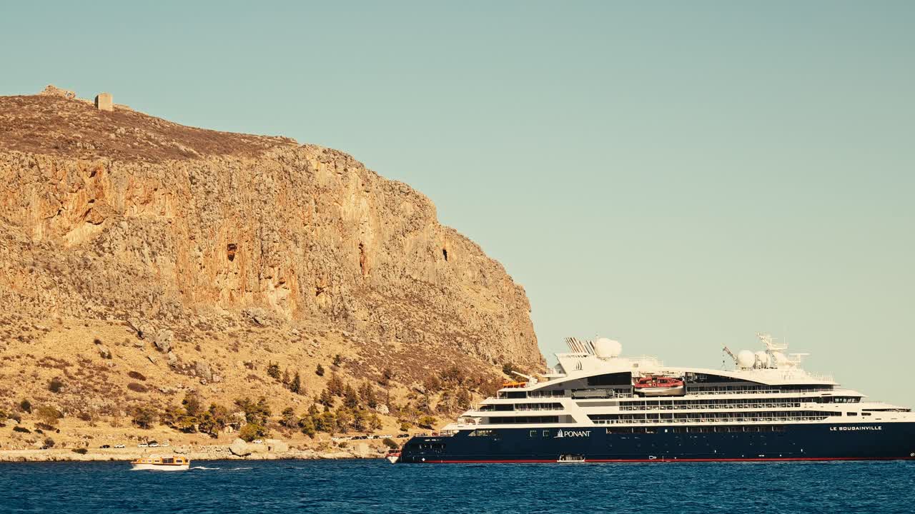 Small boat ferries cruise ship tourists passengers to Greek coastal port