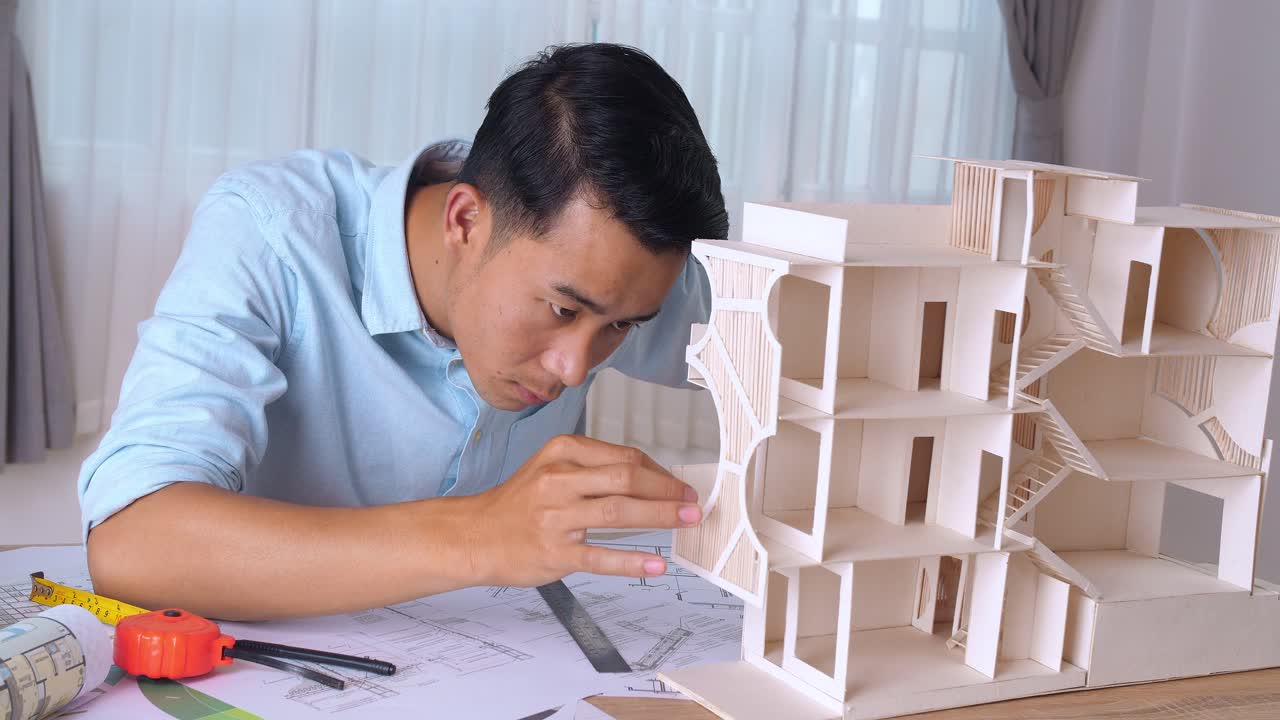 Male Architect Hands Making Model House. Man Architect Working In The Office