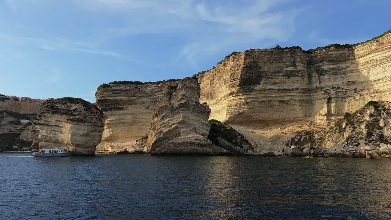 Fpv panning of Bonifacio Corse town built on high cliff seen from sailing boat along Corsica coast in France-1