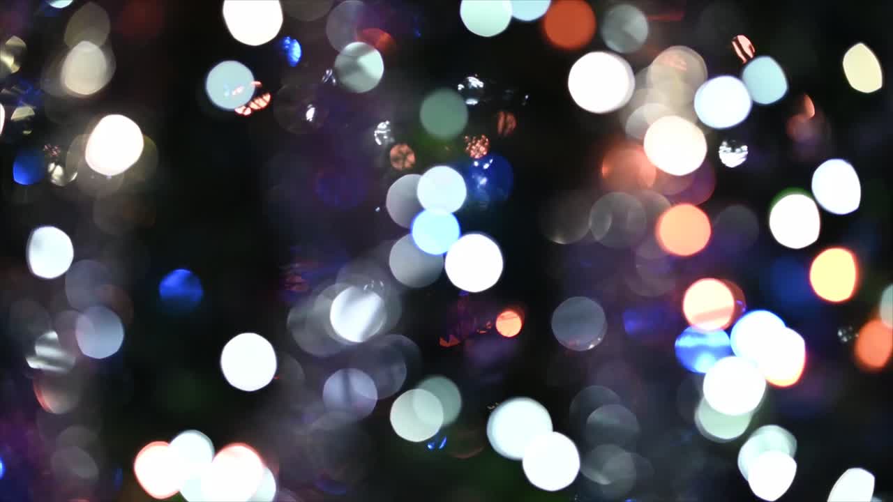 Levende bokeh-lys glitrer på en mørk baggrund.