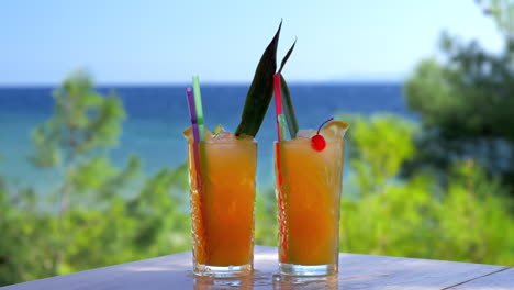 ice cubes falling into two glasses of cocktail