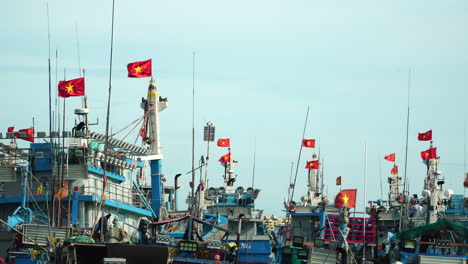 banderas vietnamitas ondean en barcos pesqueros anclados en el puerto de vinh hy, vietnam