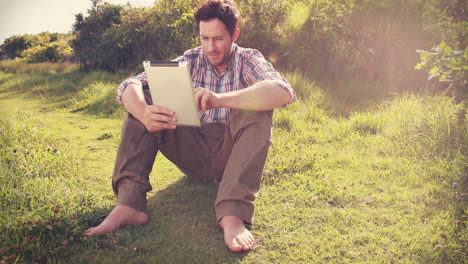 young man using tablet in the countryside