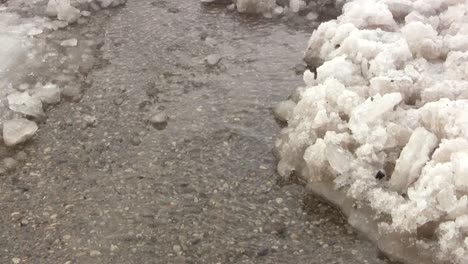el propietario despejó un camino para la escorrentía de la nieve que se derrite en primavera hacia el desagüe pluvial