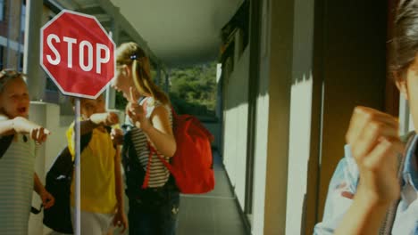 Stop-sign-over-kids-making-fun-of-school-boy-in-school-against-flickering-background