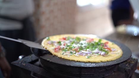Making-of-Chilla-or-Besan-cheela-is-a-simple-pancake-made-with-chickpea-flour-and-some-basic-ingredients-served-with-green-chutney-and-tomato-sauce,-also-known-as-veg-omelette