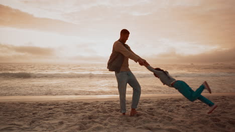 familia, playa y un padre girando a su hija