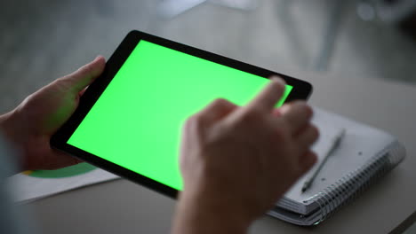 businessman swiping tablet pad green screen analyzing corporate data in office.