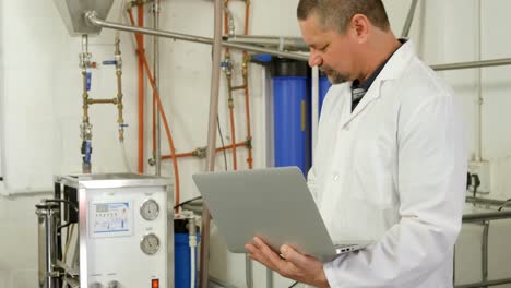 male worker using laptop in factory 4k